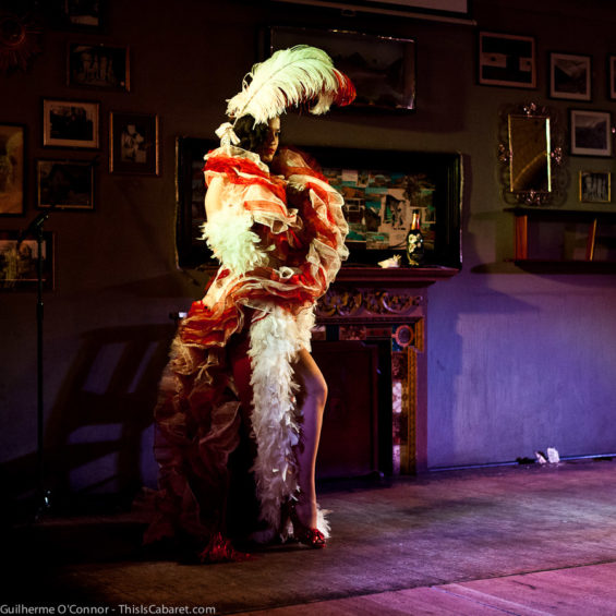 A feathered Bettsie Bon Bon goes on stage at Guttersnipes